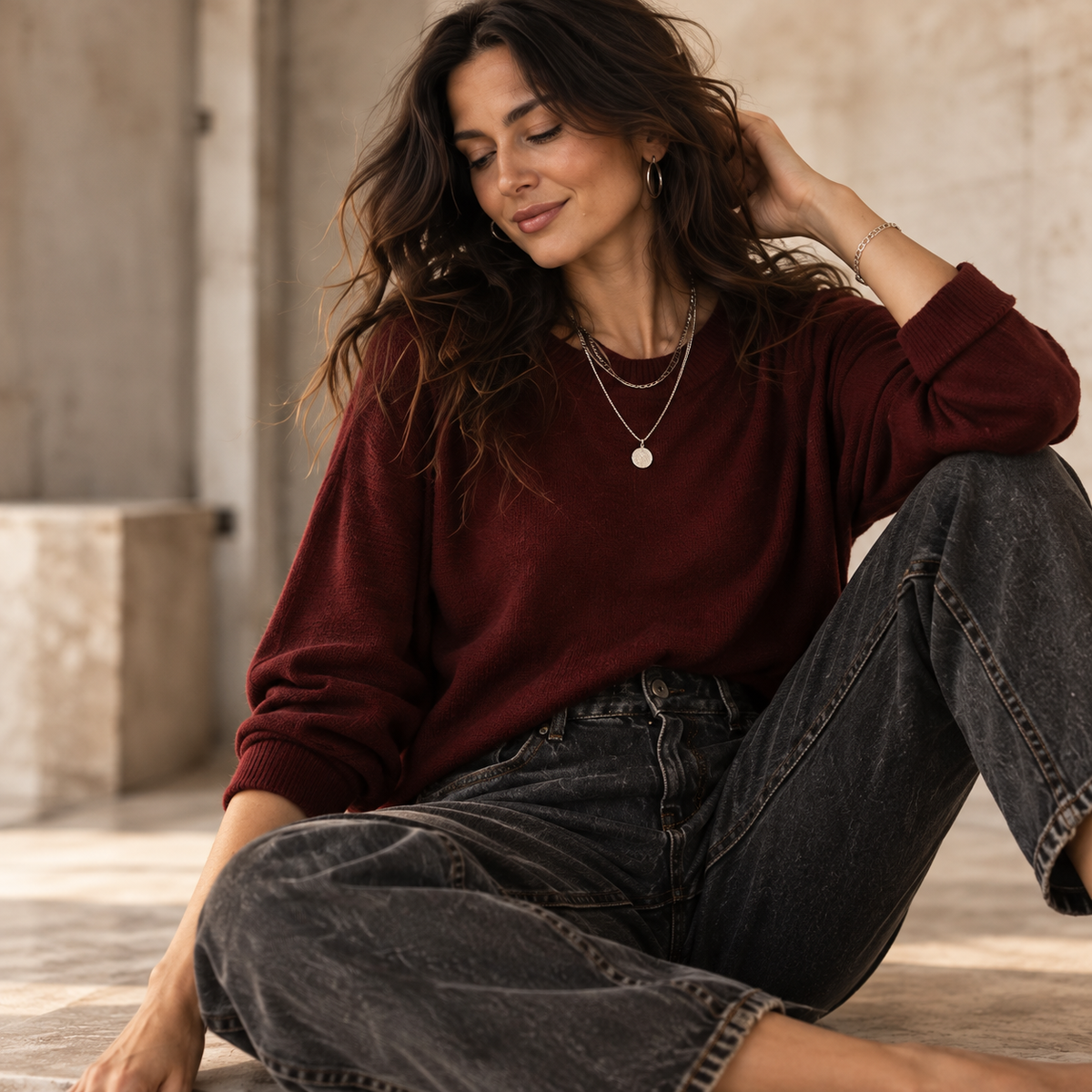 Oxblood knit with relaxed dark denim and silver jewelry
